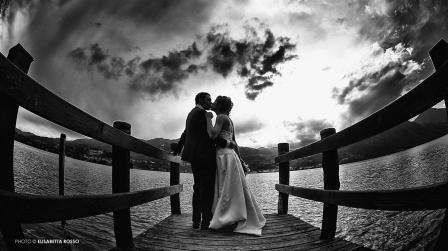 Sposi che si baciano sul molo del lago